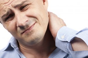 Close up portrait of a young businessman with neck pain