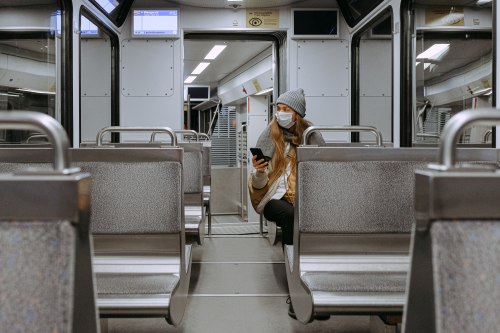 woman alone in subway car wearing a mask