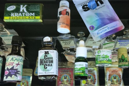 an array of jars, bottles, envelopes and other product packaging with kratom references on the labels