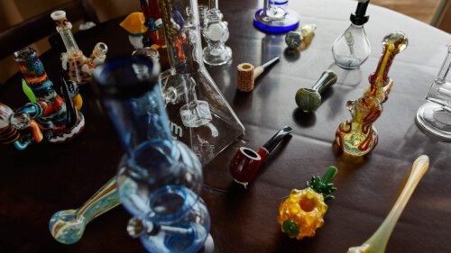 an array of different kinds of bongs and pipes on a table