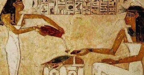 Ancient Egyptian art showing a standing person pouring liquid from a jug into a glass for a seated person, with hieroglyphic writing on the upper border between the figures.